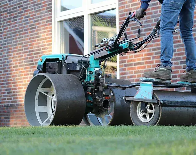 Machinaal walsen van een gazon langs een huis